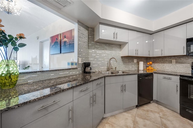 kitchen featuring sink, light tile patterned floors, black appliances, decorative backsplash, and dark stone counters