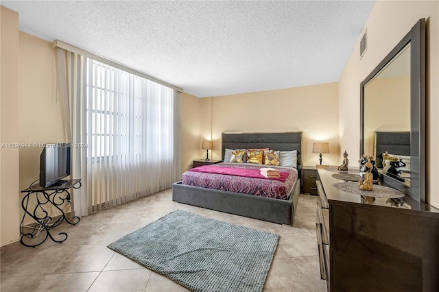 bedroom featuring light tile patterned flooring and a textured ceiling