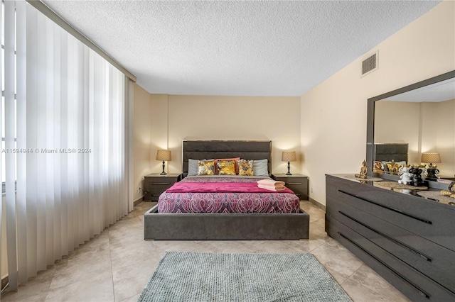 tiled bedroom featuring a textured ceiling