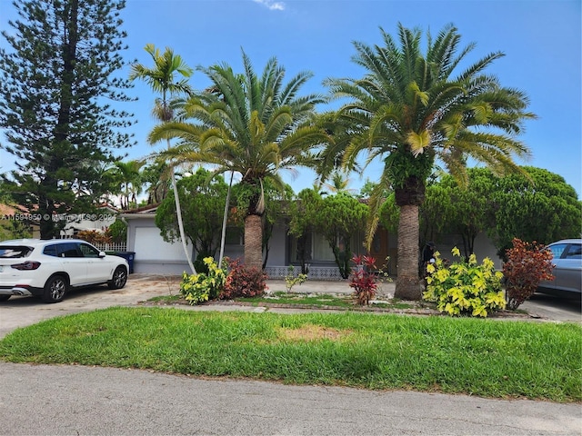 view of property hidden behind natural elements featuring a garage