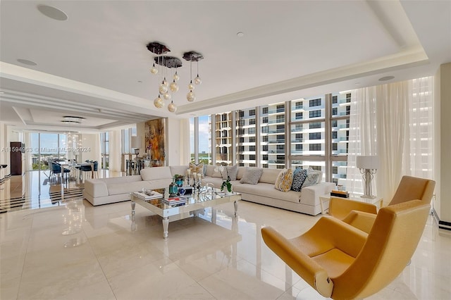 living room featuring light tile floors, expansive windows, a chandelier, and a raised ceiling