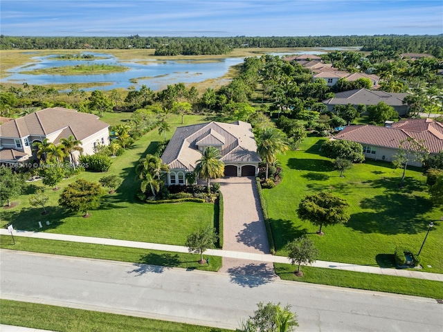 mediterranean / spanish-style home featuring a garage and a front lawn