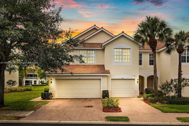 view of front of house featuring a garage and a lawn