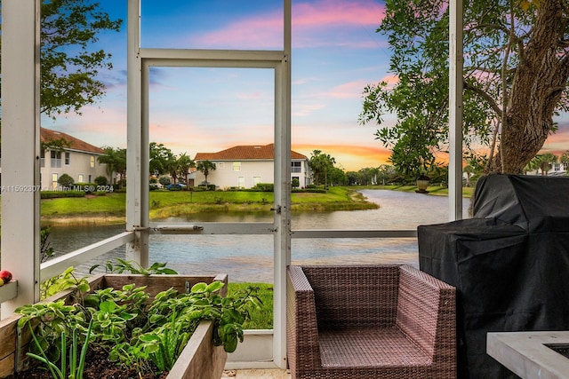 sunroom / solarium featuring a water view