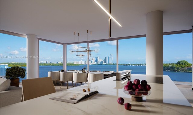 sunroom / solarium featuring a water view and a chandelier