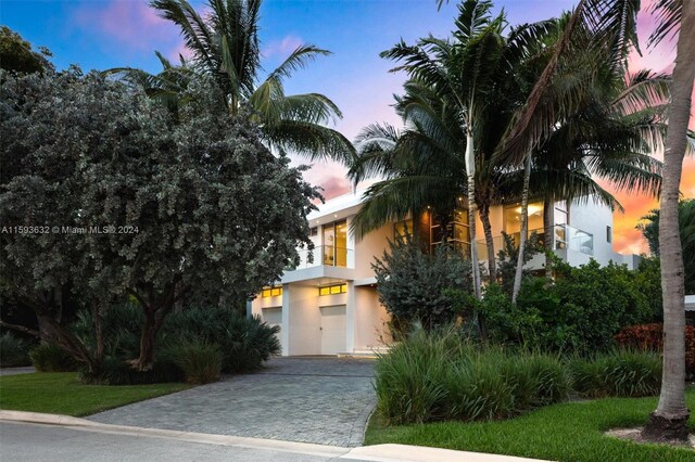 view of property hidden behind natural elements featuring a garage