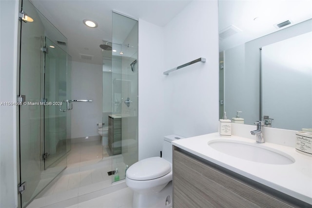 bathroom featuring a shower with door, tile flooring, toilet, and vanity