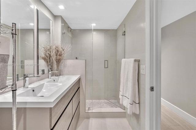 bathroom with vanity, tile walls, and a shower with shower door