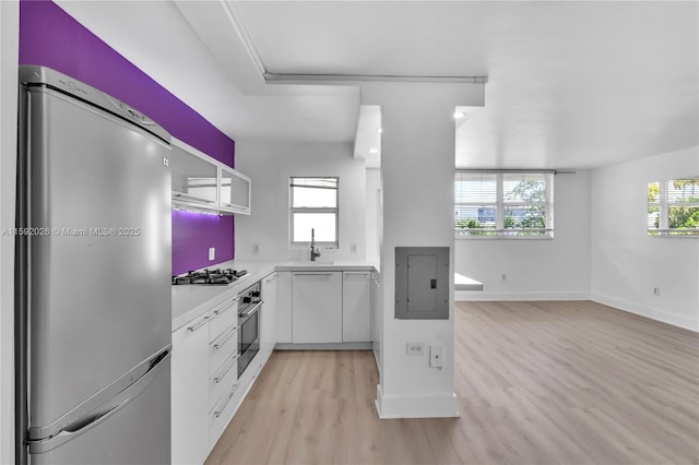 kitchen with light hardwood / wood-style flooring, a wealth of natural light, stainless steel appliances, and white cabinets