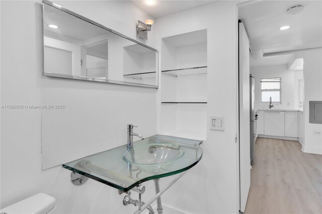 bathroom featuring sink, wood-type flooring, and toilet