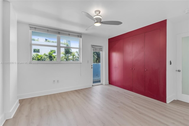 unfurnished bedroom featuring ceiling fan, a closet, light hardwood / wood-style flooring, and access to outside