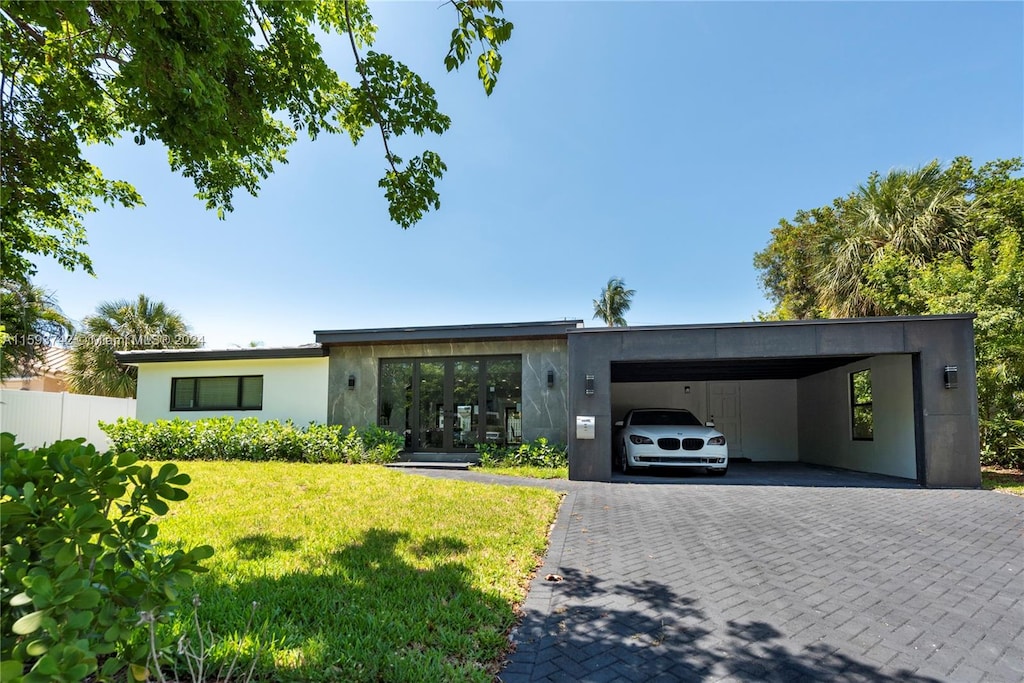 view of front of property with a front lawn and a carport