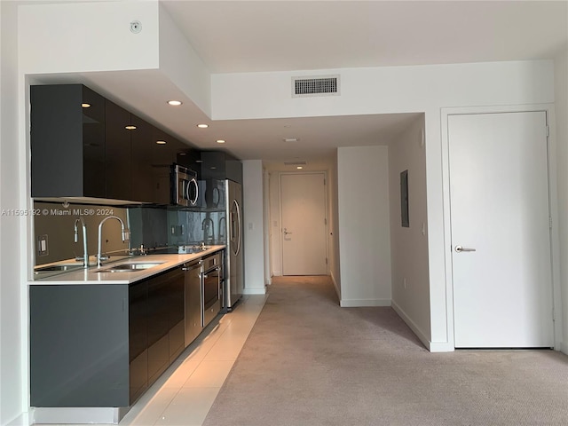 kitchen featuring light carpet, appliances with stainless steel finishes, sink, and tasteful backsplash