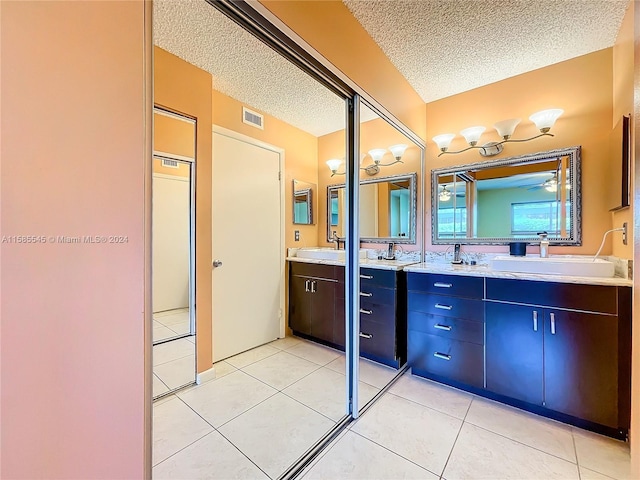 bathroom with vanity, a textured ceiling, and tile patterned floors