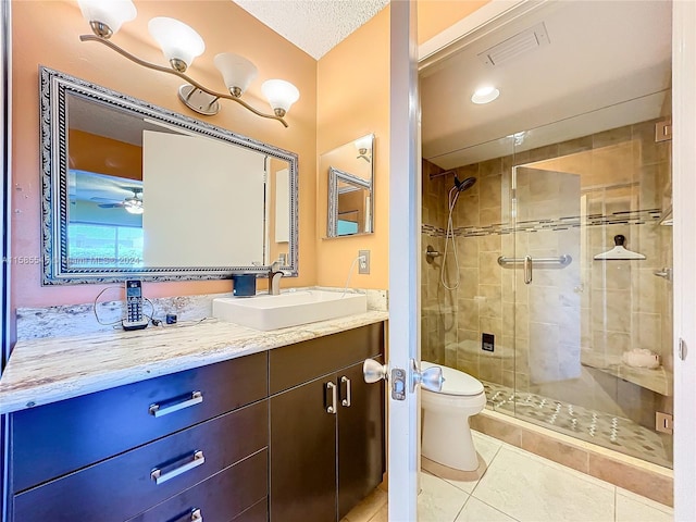 bathroom with tile patterned floors, a textured ceiling, toilet, vanity, and a shower with shower door