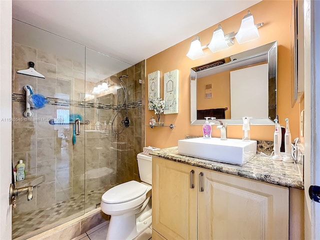 bathroom featuring tile patterned flooring, vanity, an enclosed shower, and toilet