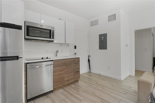 1560 Meridian Ave Unit 108, Miami Beach, FL 33139 - kitchen featuring stainless steel appliances, electric panel, light countertops, and light wood finished floors