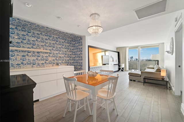 dining space with hardwood / wood-style flooring and an inviting chandelier