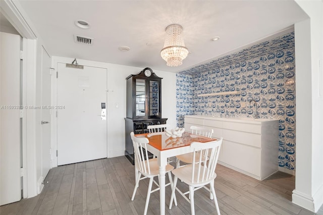 dining area with wood-type flooring and an inviting chandelier