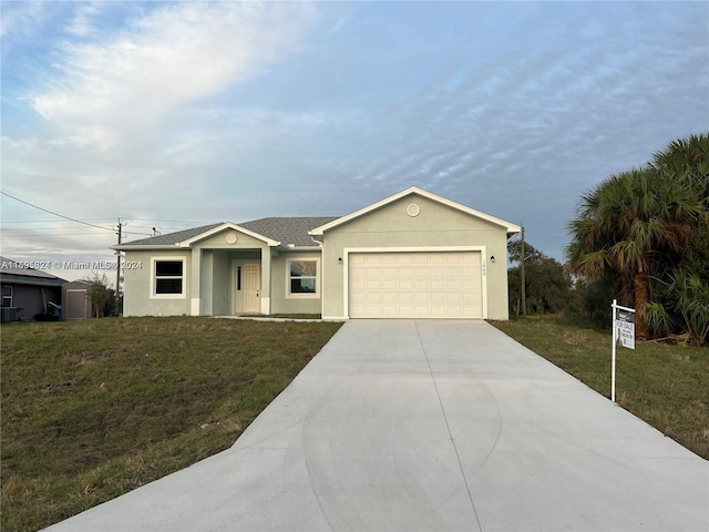 single story home with a garage and a front lawn