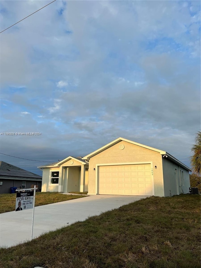 ranch-style home with a front lawn and a garage