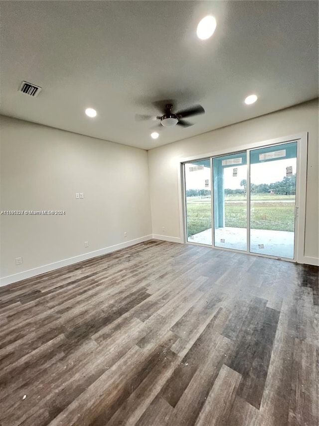 unfurnished room with a textured ceiling, dark hardwood / wood-style floors, and ceiling fan