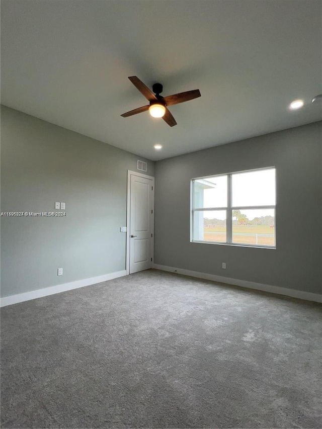 carpeted spare room featuring ceiling fan