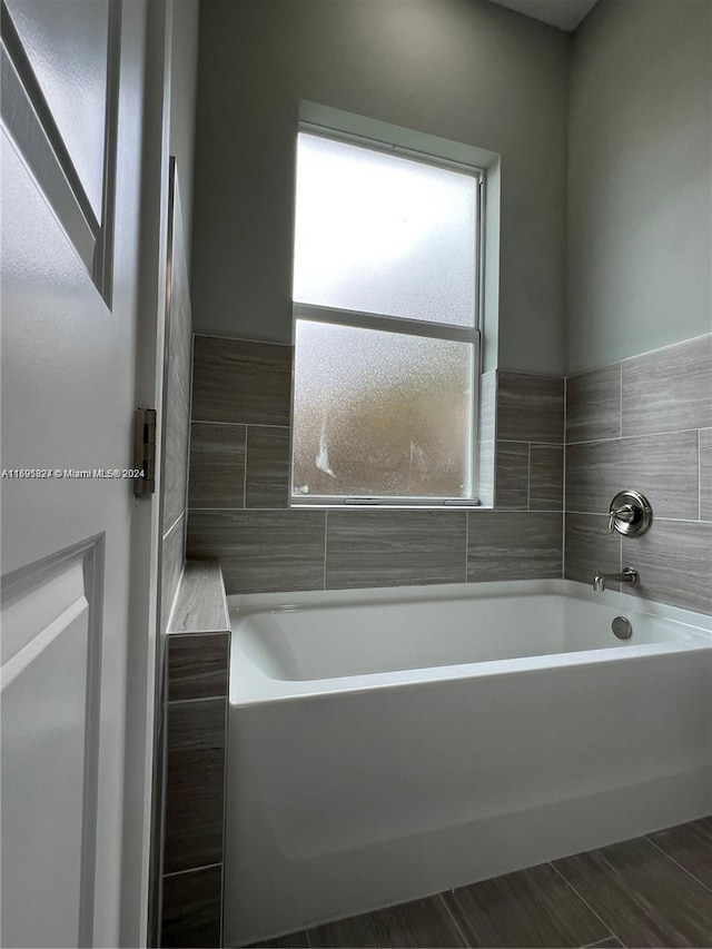 bathroom with a bathing tub and hardwood / wood-style floors