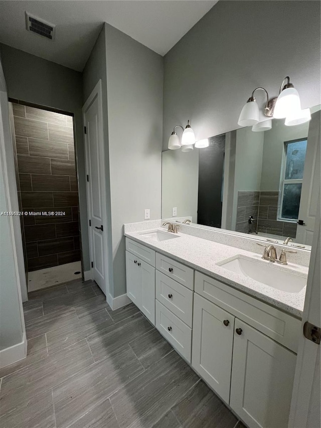 bathroom with vanity and tiled shower