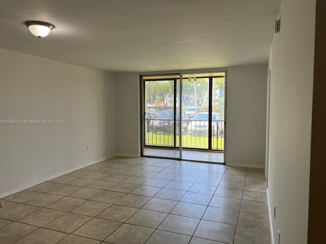 empty room featuring floor to ceiling windows and light tile patterned flooring