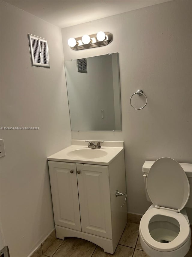 bathroom featuring vanity, tile patterned flooring, and toilet