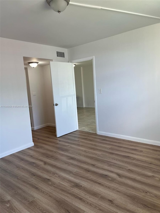 unfurnished bedroom with dark hardwood / wood-style flooring