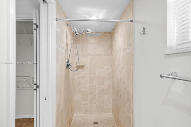 full bathroom with a spacious closet and a stall shower