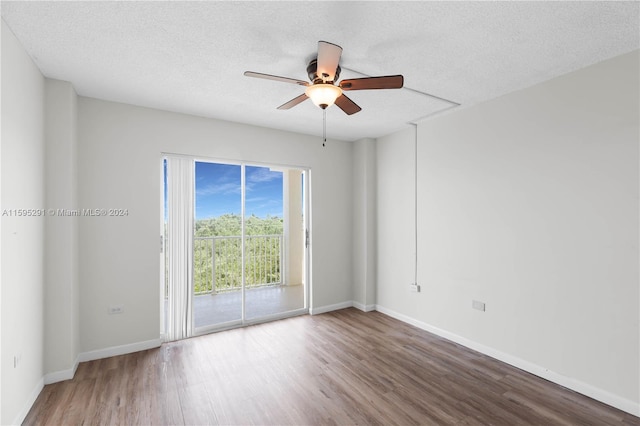 unfurnished room with ceiling fan, baseboards, a textured ceiling, and wood finished floors