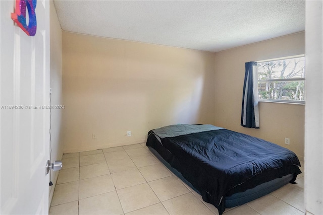 bedroom with light tile patterned floors and a textured ceiling