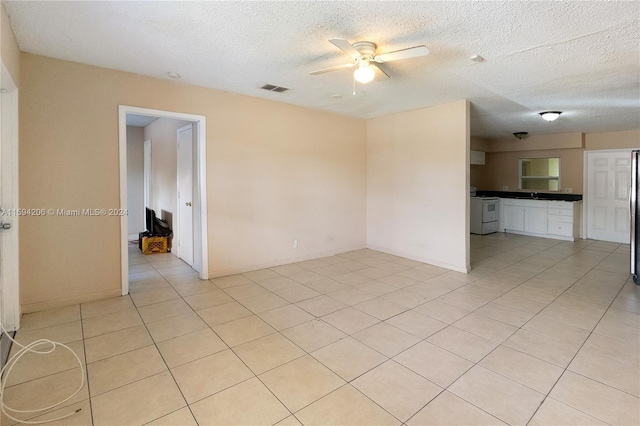 unfurnished room with a textured ceiling, ceiling fan, and light tile patterned flooring