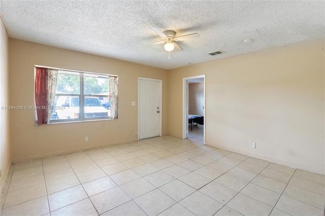 empty room featuring light tile patterned floors and a textured ceiling