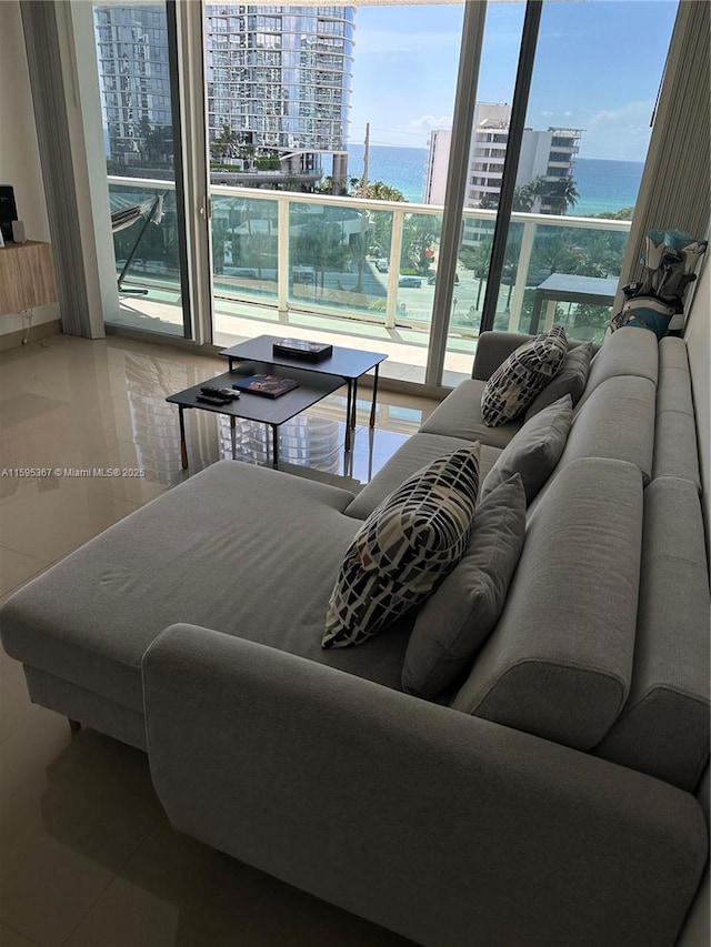 living room featuring expansive windows, a water view, and plenty of natural light