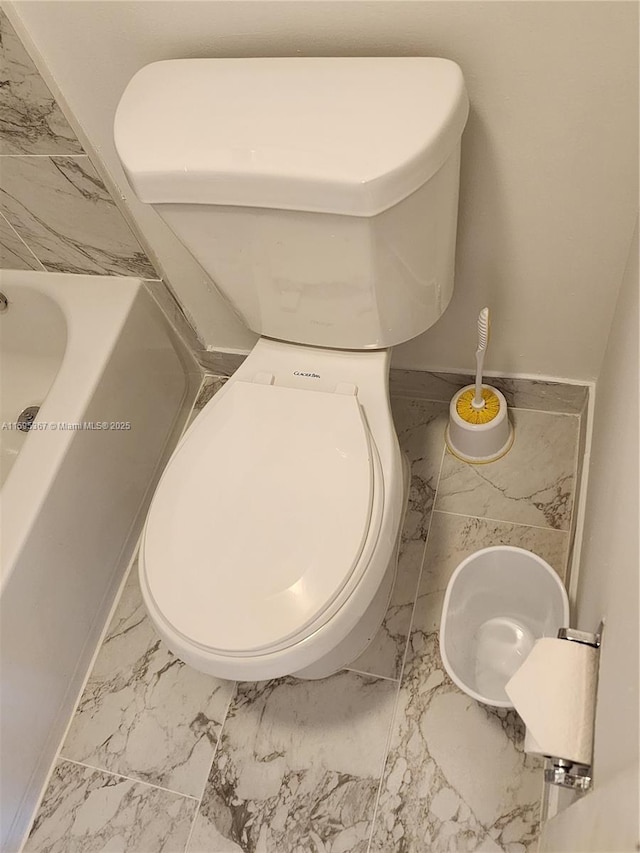 bathroom featuring a washtub and toilet