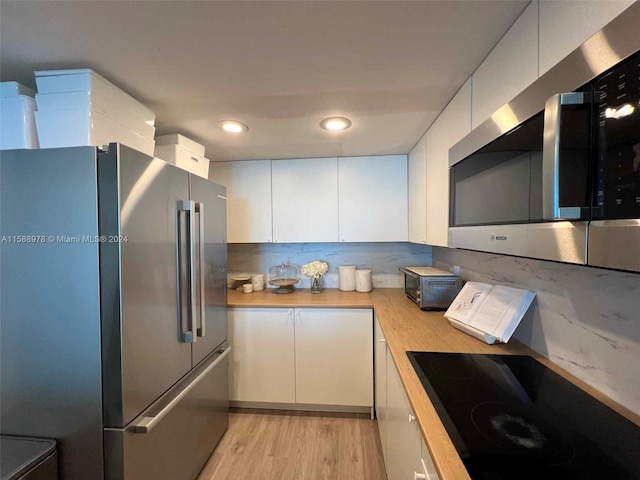 kitchen featuring stainless steel appliances, light wood-type flooring, light countertops, and white cabinets