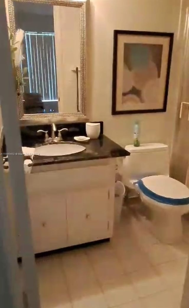 bathroom with oversized vanity, toilet, and tile floors