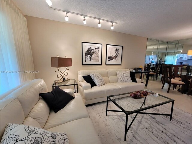 living room featuring track lighting and a textured ceiling