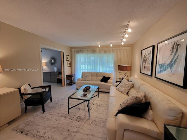 living room featuring concrete floors, a textured ceiling, and rail lighting