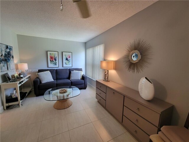 living room featuring a textured ceiling and light tile floors