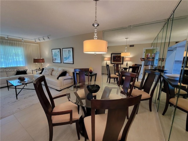 dining room featuring track lighting and light tile floors