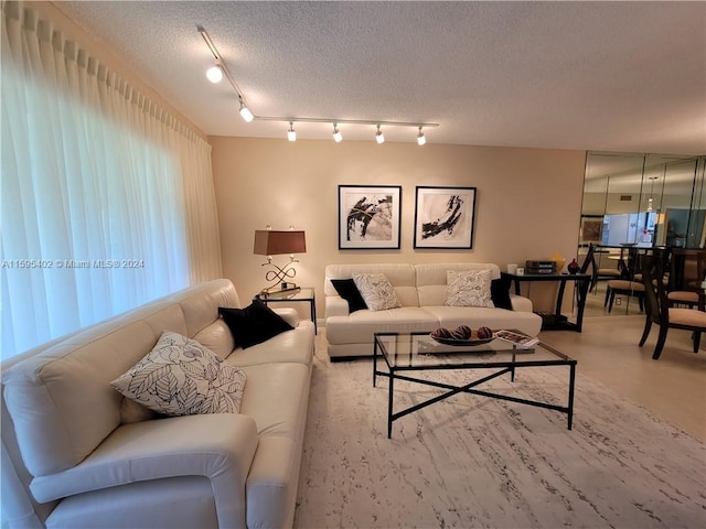 living room featuring a textured ceiling and rail lighting