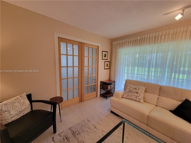 living room with french doors and a textured ceiling