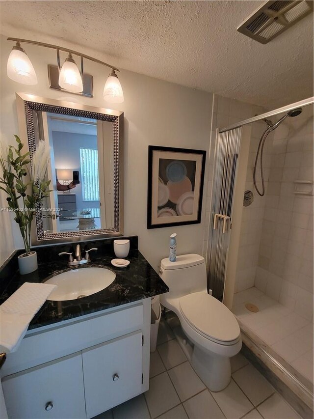 bathroom with a tile shower, tile flooring, and large vanity