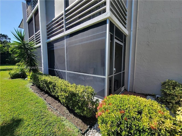 view of side of home featuring a yard and stucco siding