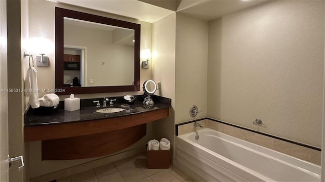 bathroom with a tub to relax in, tile patterned floors, and vanity